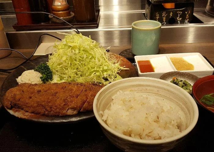 A set meal at Gyukatsu Motomura, including a bowl of rice, miso soup, wagyu beef cutlet and shredded cabbage.